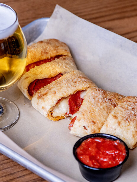 Traditional Ramundos Bites from Ramundos at Element Eatery food hall, stuffed with pepperoni and cheese, served with marinara sauce and a glass of beer on a tray